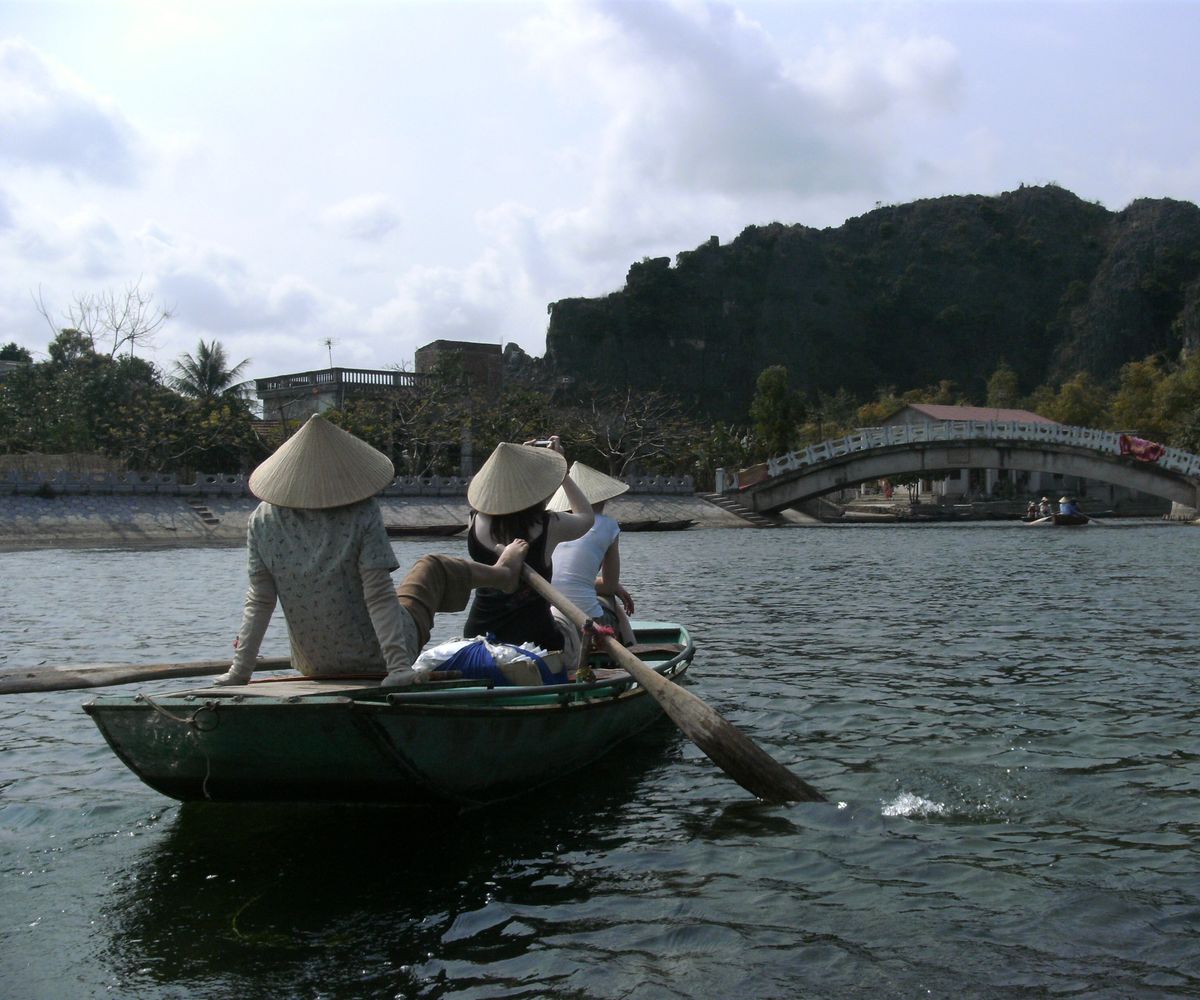 A Vietnamese woman rowing a boat with her feet to give her hands a rest.