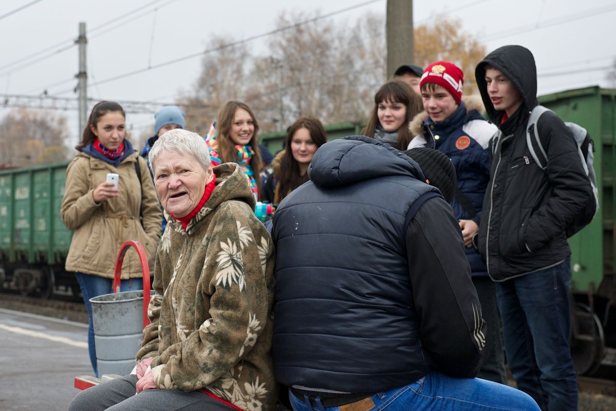 There was an old woman waiting for a train at the local station. She was talking to herself like many people of her age. The group of teenagers behind her were making fun of her... 