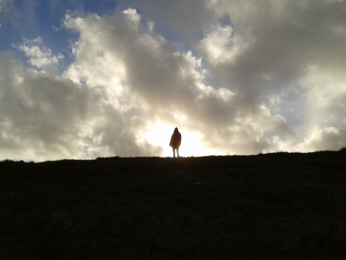 my mother standing at the top of a hill while we were at the beach, thought it would make a good picture with the light behind here,